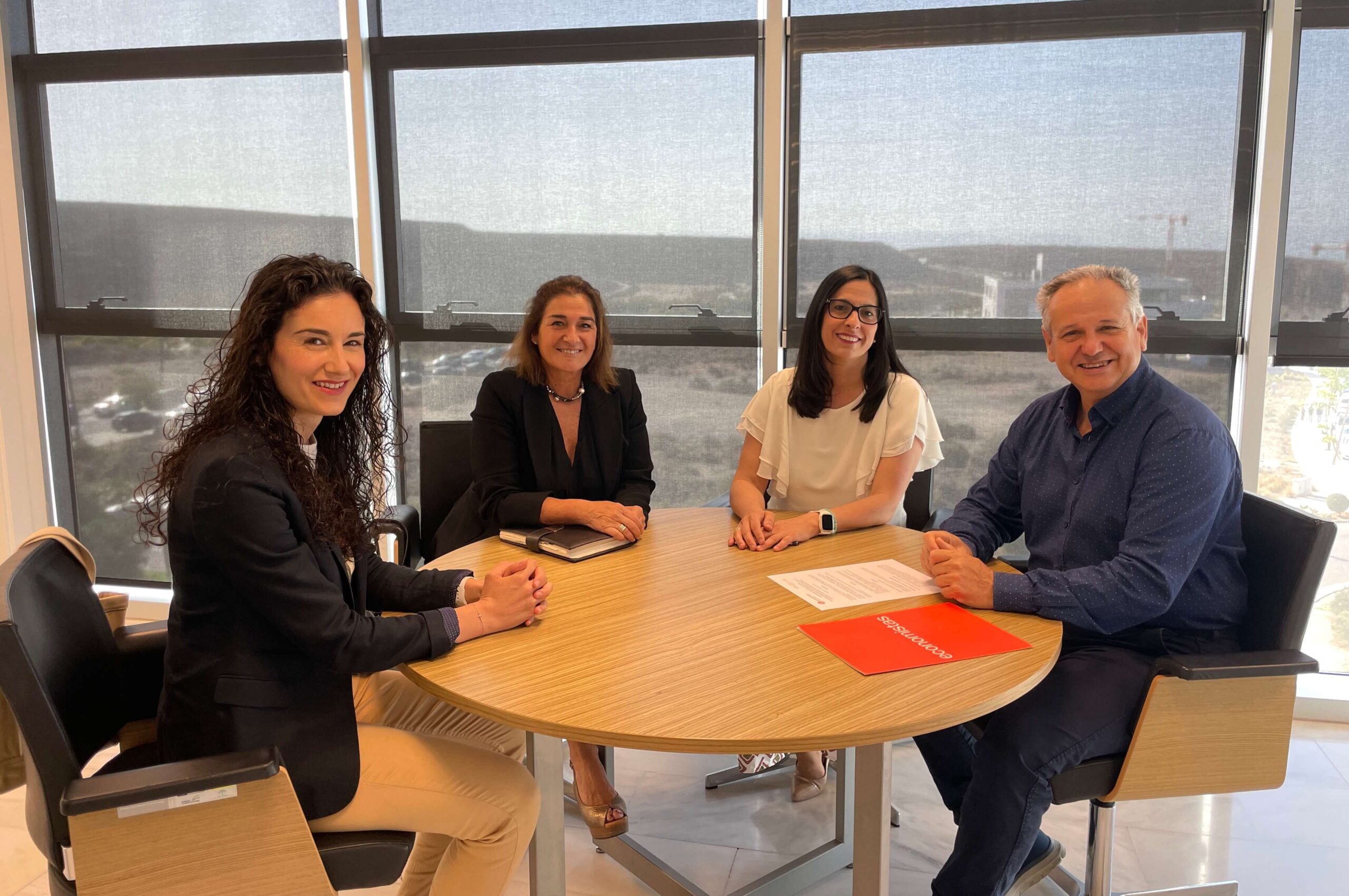 Foto de tres mujeres y un hombre sentados en una mesa