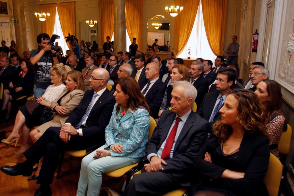 Foto de hombres y mujeres atendiendo en una sala sentados