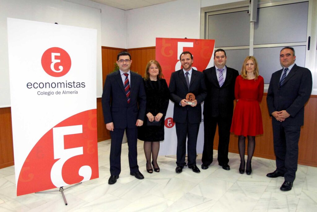 Foto de cuatro hombres y dos mujeres con un premio
