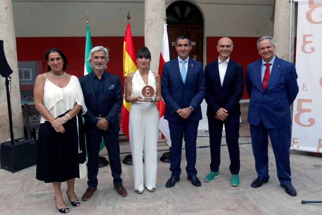 Foto de dos mujeres y cuatro hombres con un premio