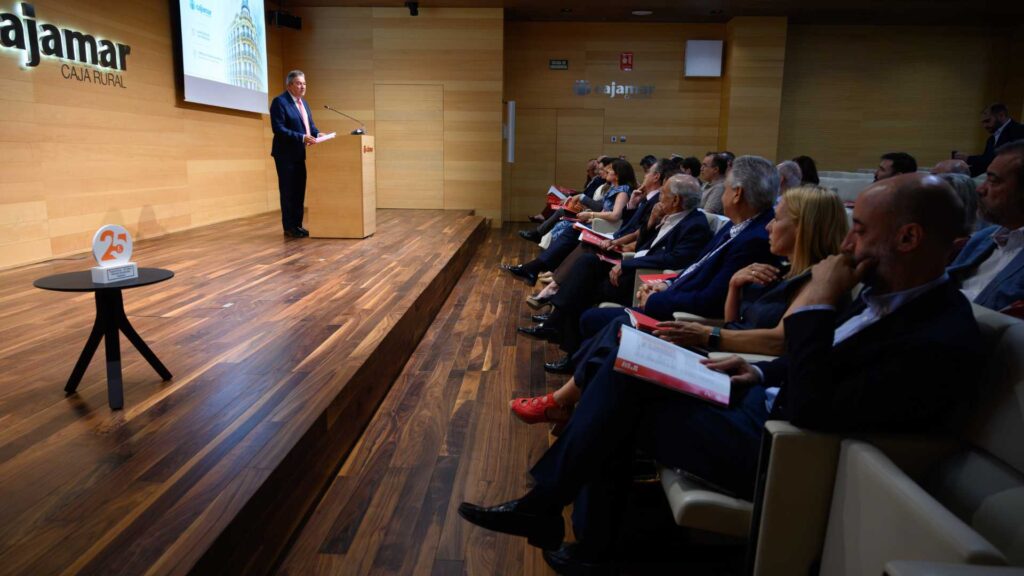 Vista lateral del salón de actos con asistentes siguiendo la presentación de Trayectoria 25 · Cajamar.