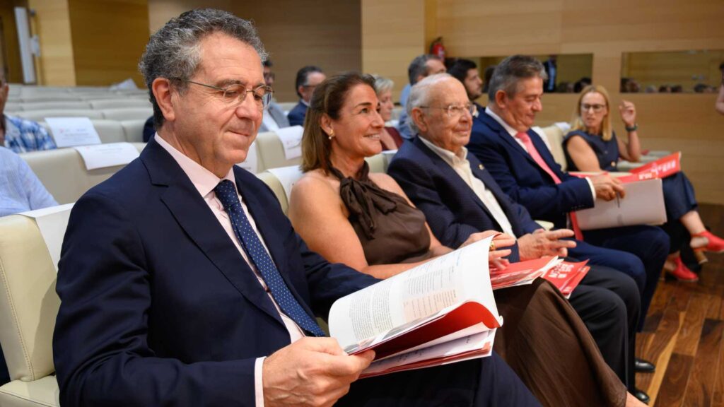 Asistentes al acto consultan la publicación Trayectoria 25 · Cajamar durante la presentación institucional.