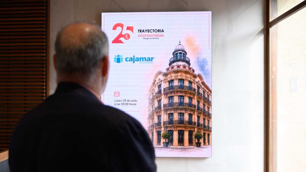 Ponente ante la pantalla de presentación de la publicación Trayectoria 25 dedicada a Cajamar y al Premio Economía.